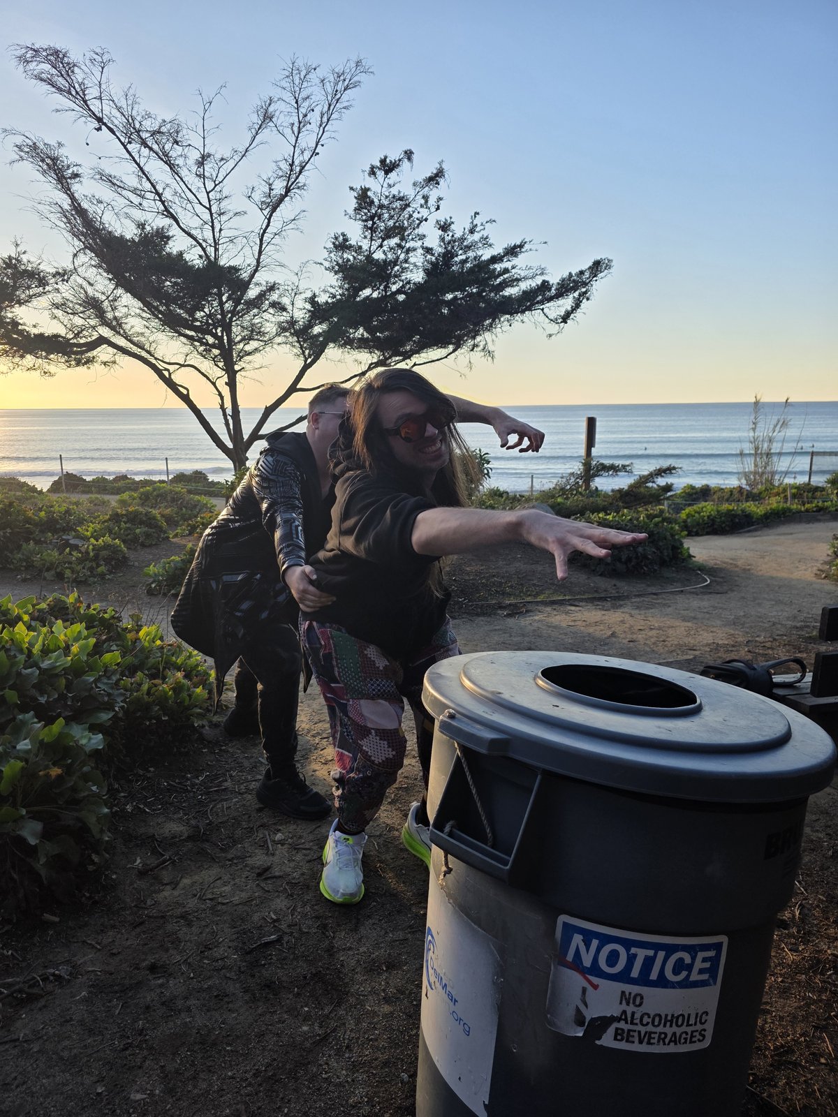 Second angle of Goose being carried toward the trash can, reaching dramatically toward the ocean
